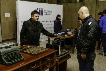 Funcionario del Ministerio de Hacienda, dando a conocer a los visitantes material de trabajo antiguo de la institución.