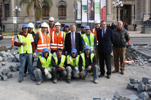 En la imagen: el ministro de Hacienda, Felipe Larraín, y el presidente de la Cámara Chilena de la Construcción, Gastón Escala, junto a los trabajadores encargados de la repavimentación de la Av. José Miguel de la Barra, justo en el frontis del Museo Nacional de Bellas Artes.