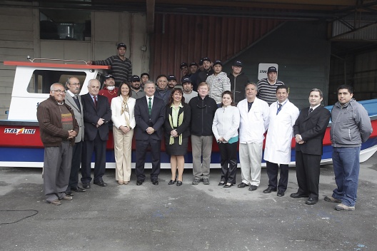 Los ministros de Hacienda, Felipe Larraín, y Obras Públicas, Loreto Silva junto a trabajadores de fábrica de botes